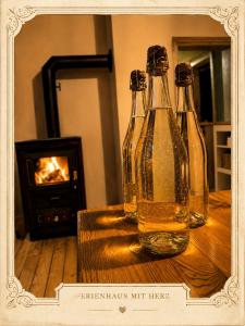 two bottles of beer sitting on a table with a fireplace at Emma's Vintage Ferienhaus mit Kamin in Friedrichsbrunn
