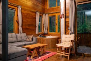 a living room with a couch and a table and chairs at Saffire Doğa Evleri in Güneyköy
