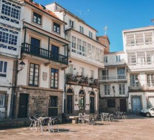 a group of buildings with tables and chairs in front of them at Adiva A Zapataría in Puentedeume