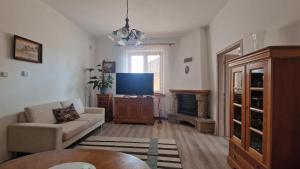 a living room with a couch and a flat screen tv at Apartment LAURA in Žilina