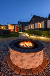 a brick fire pit in the middle of a yard at Domki DOMINO w Darłówku nad morzem in Darłowo