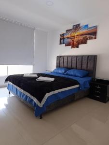 a bedroom with a large bed with blue pillows at Apartamento san gil plaza in San Gil +7 photos