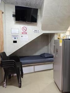 a room with a bed and two chairs and a tv at APARTAMENTOS LIZ MARIA in Coveñas