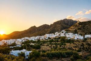 a group of white houses on a hill at sunset at Refugio rural en Níjar con jardín privado barbacoa y solarium con vistas únicas in Níjar
