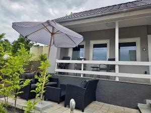 a patio with chairs and an umbrella on a house at Ferienhäuschen mit Wellnessbereich in Marsberg