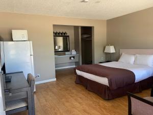 a hotel room with a large bed and a desk at Rondo Motel in Golden