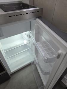 an empty refrigerator with its door open in a kitchen at Ferienhäuschen mit Wellnessbereich in Marsberg +8 photos