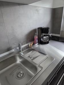 a kitchen counter with a sink and a coffee maker at Ferienhäuschen mit Wellnessbereich in Marsberg