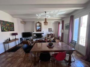 a living room with a table and chairs at Grande maison familiale proche mer in Elne
