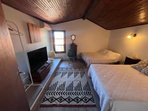 a bedroom with two beds and a flat screen tv at Grande maison familiale proche mer in Elne
