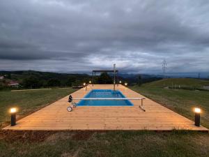 ein Schwimmbad auf einem Feld mit Lichtern in der Unterkunft ATETA Tiny House in Dealu Mare