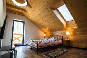 a bedroom with a bed in a room with wooden ceilings at Ranczo Lanckorona in Kalwaria Zebrzydowska