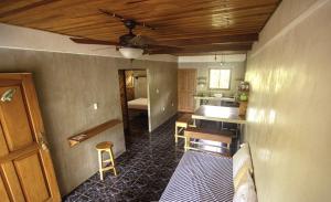 a living room with a ceiling fan and a kitchen at Don Jon's Surf and Yoga Lodge in Santa Teresa Beach +70 photos