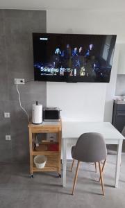 a desk with a tv and a table with a chair at Ferienhäuschen mit Wellnessbereich in Marsberg