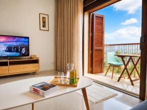 a living room with a view of a balcony at Harba - An Escape at Fort Chambray in Għajnsielem