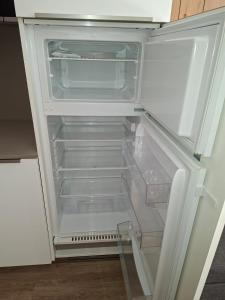 an empty refrigerator with its door open in a kitchen at Nido Silmano in Marilleva