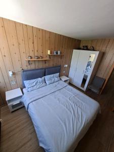 a large bed in a room with wooden walls at Nido Silmano in Marilleva