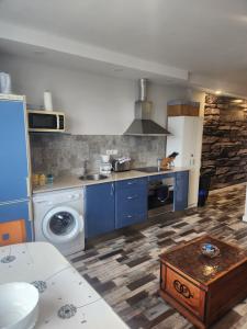 a kitchen with blue cabinets and a washing machine at Apartamento Sol in Suances