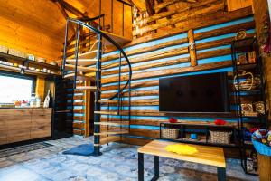 a wooden wall with a spiral staircase in a living room at Ranczo Lanckorona in Kalwaria Zebrzydowska