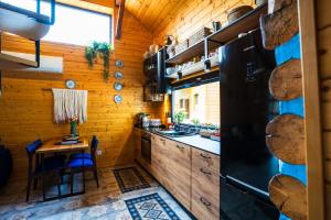 a kitchen with wooden walls and a table and a refrigerator at Ranczo Lanckorona in Kalwaria Zebrzydowska