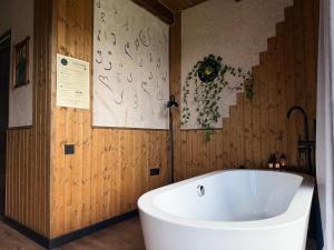 a white bath tub in a bathroom with wooden walls at Mtaura Cabins in Kazbegi +21 photos