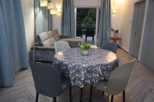 a dining room with a table with chairs and a couch at Maison des Anges in Mahébourg
