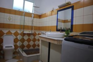 a bathroom with a sink and a toilet and a mirror at Maison des Anges in Mahébourg