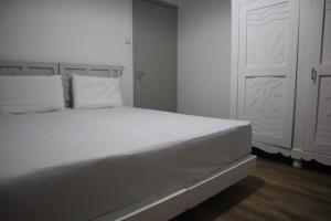 a white bed with white pillows in a bedroom at Maison des Anges in Mahébourg +12 photos