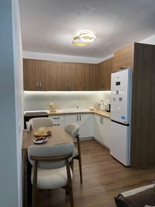 a kitchen with a table and a white refrigerator at Topuzi Grand House in Pogradec