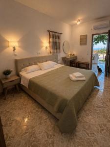 a bedroom with a large bed with two towels on it at Mihalis Studios in Karpathos