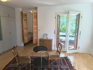 a living room with a table and chairs and a window at Pine Breeze in Punat