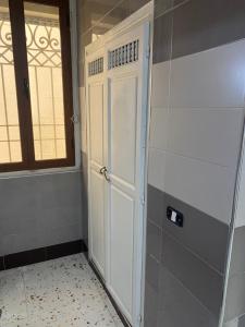 a white door in a room with a window at Hôtel Agriculture in Tunis