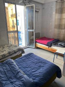 a bedroom with a bed and a large window at Hôtel Agriculture in Tunis