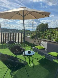 a patio with two chairs and an umbrella at Mia Bella in Sremska Kamenica