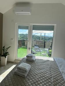 a bedroom with a bed with towels on it at Mia Bella in Sremska Kamenica