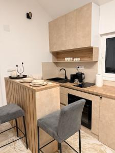 a kitchen with a counter and some chairs in it at Mia Bella in Sremska Kamenica