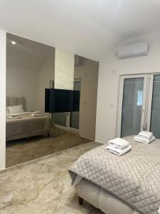 a bedroom with two beds and a large mirror at Mia Bella in Sremska Kamenica