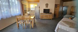a room with a table and a kitchen with a bed at By Karin in Kranevo