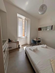 a white bedroom with a bed and a table at Villa Martina Luxury Suites Como Lake in Lecco