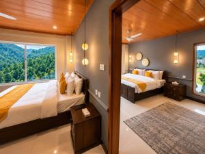 two beds in a room with a large window at Grand Montis Hotel in Abbottabad +61 photos
