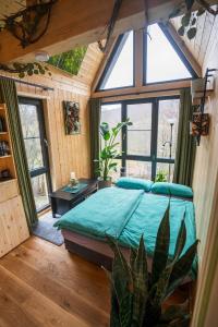 a bedroom with a bed in a room with windows at Taunus Tinyhouse - Sauna, Grillplatz & Naturidylle in Weilrod