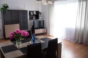 a dining room with a table with pink flowers on it at Płock City Center Apartment in Płock
