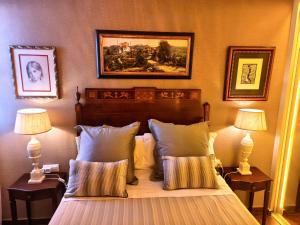 a bedroom with a bed with two lamps and a painting at La Terraza del Castillo- Playa de Rota in Rota