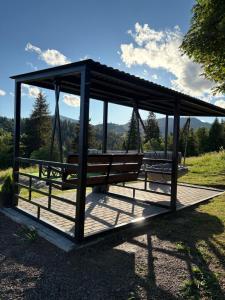 a pavilion with two benches in a park at Karpatski Prostory in Slavske