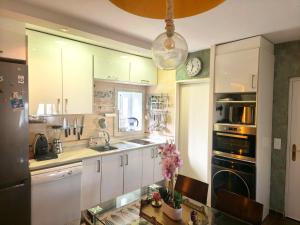 a kitchen with white cabinets and a clock on the wall at La Terraza del Castillo- Playa de Rota in Rota