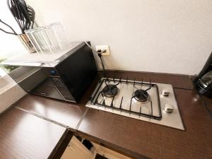 a kitchen counter with a stove and a microwave at Loft Sipeh Xalapa Departamento 4 in Xalapa +40 photos