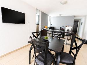 a dining room with a table and a television on a wall at Loft Sipeh Xalapa Departamento 4 in Xalapa