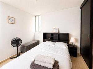 a bedroom with a large white bed with a chair at Loft Sipeh Xalapa Departamento 4 in Xalapa