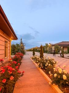 a sidewalk with red and white flowers next to a building at Nomad Resort Cholpon-Ata in Cholpon-Ata