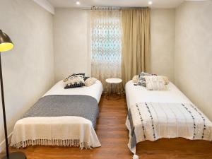 a bedroom with two beds and a window at Retiro São Pedro House in Aldeia da Mata
